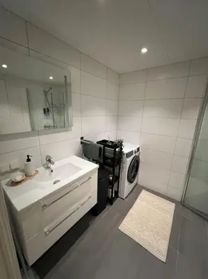 a bathroom with a sink and a washing machine at SKI VM - Trondheim 2025 in Heimdal