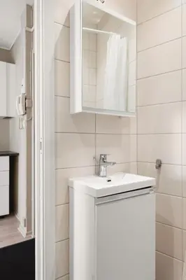 a white bathroom with a sink and a mirror at Cozy studio in Bergen center in Bergen