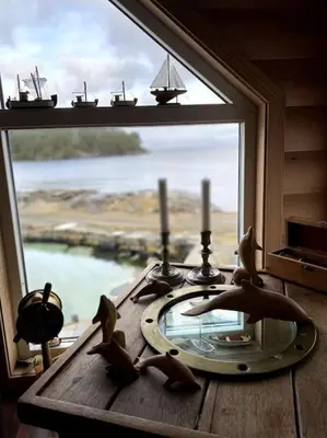 a window with a glass table with birds on it at Moderne Rorbu helt i sjøkanten in Hauge