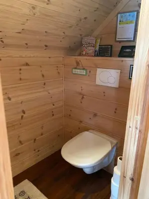 a small bathroom with a toilet in a wooden wall at Moderne Rorbu helt i sjøkanten in Hauge