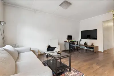 a living room with a white couch and a tv at Stylish & Modern Apartment, in Centre, Free Parking spot ! in Trondheim