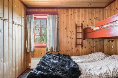 a bedroom with a bed in a wooden room at Leilighet sentralt i Trysil in Hovi