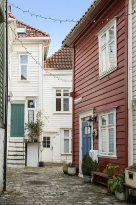 a red and white house with a bench in front of it at Historisk hus i hjertet av byen in Bergen