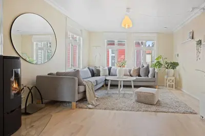 a living room with a couch and a mirror at Historisk hus i hjertet av byen in Bergen