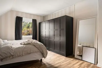 a bedroom with a bed and a window and a mirror at Trolltunga Fjord View in Tokheim