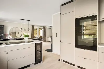 a kitchen with white cabinets and a sink at Trolltunga Fjord View in Tokheim