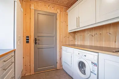a laundry room with a washer and dryer at Tovebu Superior 9-sengshytte in Geilo