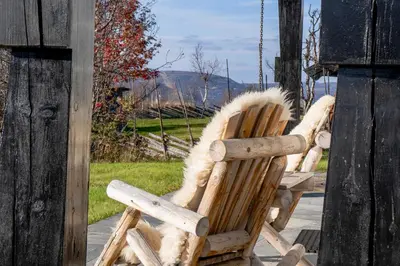two rocking chairs with faux fur sitting on a porch at Tovebu Superior 9-sengshytte in Geilo