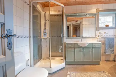 a bathroom with a shower and a sink and a toilet at Tovebu Superior 9-sengshytte in Geilo
