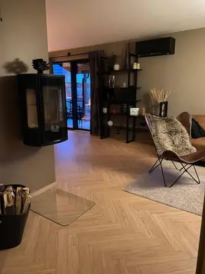 a living room with a tv on the wall and a chair at Totalrenovert enebolig i rolige omgivelser in Trondheim