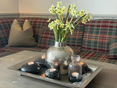 a vase with flowers and candles on a table at Cozy 3 Bedroom, Terrace, Pets Welcome in Beitostøl