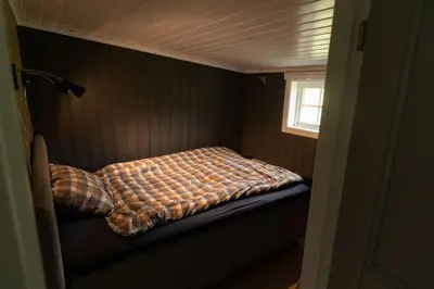 a bed in a small room with a window at Cozy apartment close to the ski resort in Oppdal