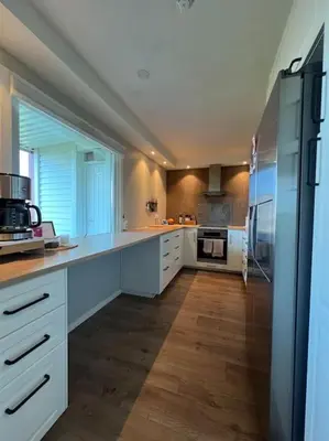 a large kitchen with white cabinets and appliances at Bolig til leie under ski-VM 2025 in Trondheim