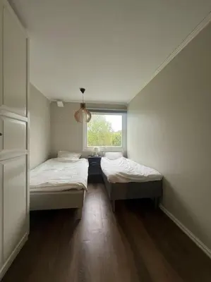 two beds in a small room with a window at Bolig til leie under ski-VM 2025 in Trondheim