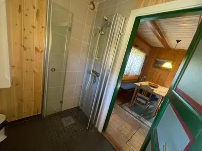 a bathroom with a shower and a table in a room at Old Cabin Vibe, Perfect For Families Or Couples in Beitostøl