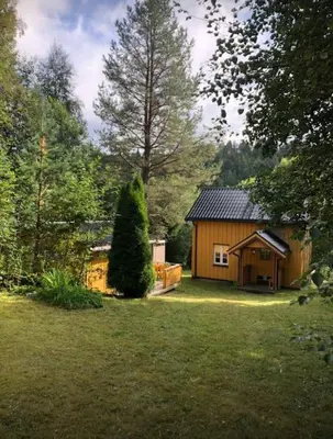 a small cabin in a yard with a tree at Rindalsskogen cabin in Løfald