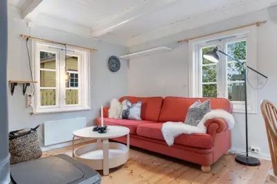 a living room with a red couch and a table at Rindalsskogen cabin in Løfald