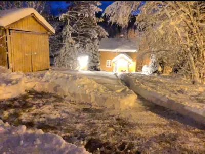 a house in the snow with a light at Rindalsskogen cabin in Løfald