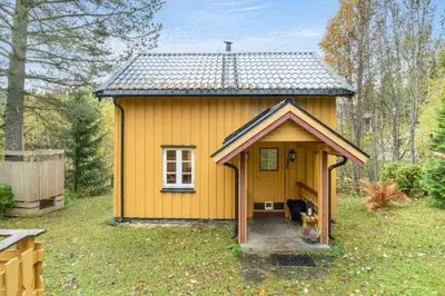 a small yellow tiny house in a yard at Rindalsskogen cabin in Løfald