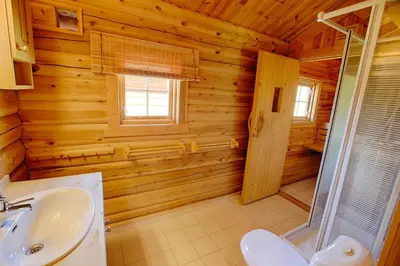 a bathroom with a toilet and a sink in a log cabin at Perfectly Located Timber Cabin For 6-8 Guests in Beitostøl