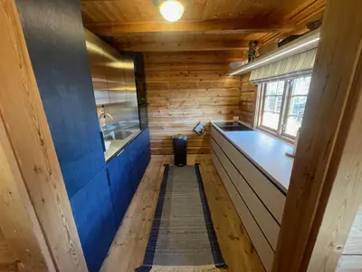 a kitchen with wooden walls and a blue counter top at Perfectly Located Timber Cabin For 6-8 Guests in Beitostøl