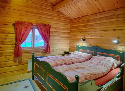 a bedroom with a bed in a log cabin at Perfectly Located Timber Cabin For 6-8 Guests in Beitostøl