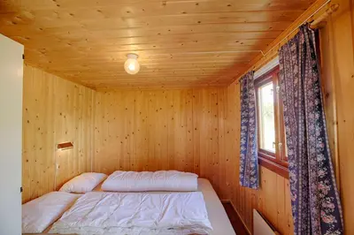 a bed in a wooden room with a window at Charming Cabin With Old Timber, Fireplace & Views in Beitostøl