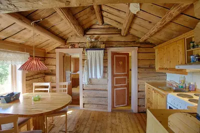 a kitchen and dining room with a table in a log cabin at Charming Cabin With Old Timber, Fireplace & Views in Beitostøl