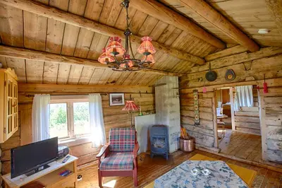a living room with a chandelier in a log cabin at Charming Cabin With Old Timber, Fireplace & Views in Beitostøl
