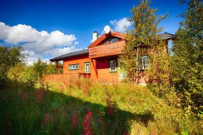 a house sitting on top of a grassy field at Familiehytte Med Peis Og Badstu I Sentrum in Beitostøl