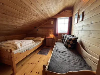 a bedroom with two beds in a log cabin at Familiehytte Med Peis Og Badstu I Sentrum in Beitostøl