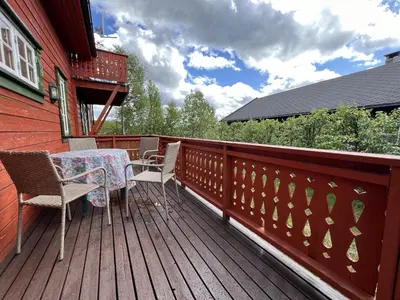 a wooden deck with a table and chairs on it at Familiehytte Med Peis Og Badstu I Sentrum in Beitostøl