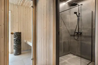 a shower with a glass door in a bathroom at Tenden Panorama in Stryn