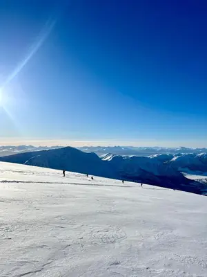 a group of people skiing down a snow covered slope at Tenden Panorama in Stryn