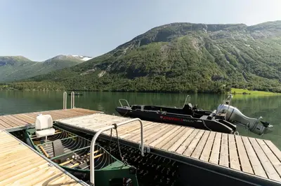 a boat is docked at a dock on a lake at Tenden Panorama in Stryn
