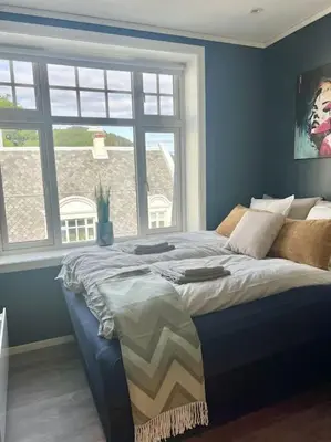 a bed in a room with a large window at Hellegata 5 - in the heart of Ålesund in Ålesund