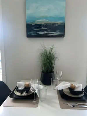 a table with two plates and wine glasses on it at Hellegata 5 - in the heart of Ålesund in Ålesund