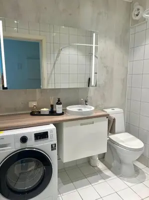 a bathroom with a washing machine and a toilet at Hellegata 5 - in the heart of Ålesund in Ålesund