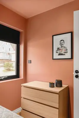 a bedroom with orange walls and a dresser and a window at Odda Trolltunga Atmosphere in Odda