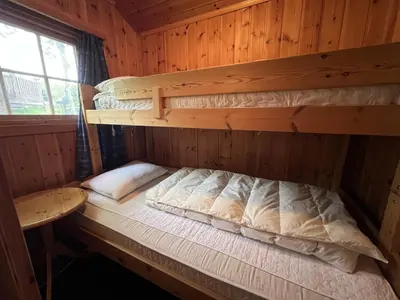 a bedroom with two bunk beds in a cabin at Koselig Sentral Eldre Hytte Med Peis in Beitostøl