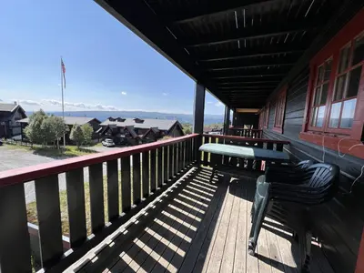 a bench sitting on a porch of a building at Your Perfect Base In Beitostølen Sleeps 8! in Beitostøl