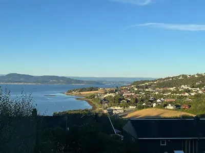 a view of a body of water with houses and a town at Eget rom og bad med delt kjøkken, 15 minutter fra Trondheim in Malvik