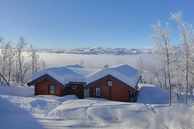 a log cabin with snow on the roof at Mountain Getaway With Sauna And Views in Beitostøl