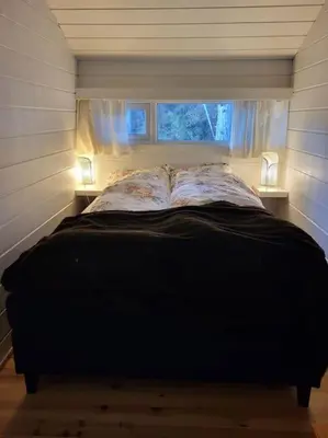 a bed in a small room with a window at Cabin on an beautiful island with a sea view in Vinsternes
