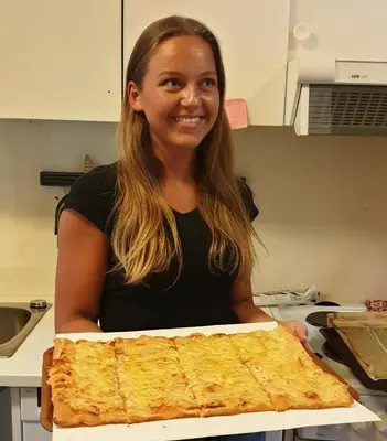 a woman is holding a pizza in a box at Bøyum Camping in Fjarland