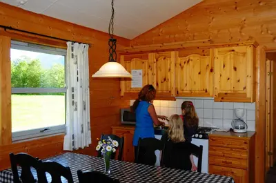 a woman and two girls in a kitchen at Bøyum Camping in Fjarland
