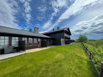 an exterior view of a building with a green yard at Perfect Retreat For Small Families in Beitostøl
