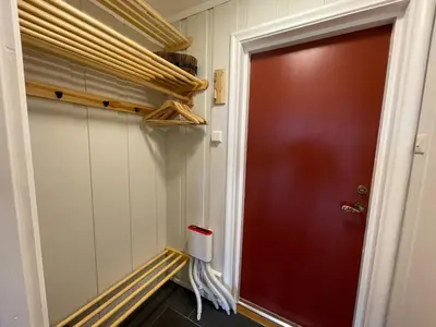 a hallway with a red door and a shelf at Perfect Retreat For Small Families in Beitostøl