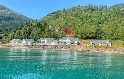 a group of houses on the shore of a river at 4 Bedroom Awesome Home In Luster in Luster