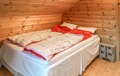 a bed in a wooden room with a wooden wall at 4 Bedroom Awesome Home In Luster in Luster